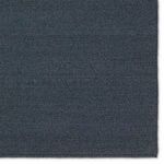 Close crop portraying tight natural-inspired weave pattern on the blue rug's surface.