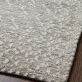 Close-up of rug surface highlighting pattern contrast and low-profile edge on dark wood flooring