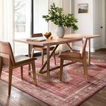 Heidi Sunset Natural Rug under a dining table with wooden chairs, styled in a sunlit modern dining room