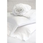 Folded white bamboo pillowcases and rolled fitted sheet stacked on a flat surface