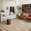 Rug in a different living room with white sofa, brown leather armchairs, wooden floors, and natural decor
