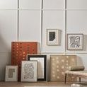 Gallery wall above rustic bench featuring painting alongside neutral abstract art