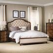 Side angle of Leesburg Upholstered Headboard showing mahogany veneer detail in a styled bedroom with dresser