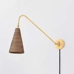 Side angle view highlighting curve of the brass arm and wall mount with black cord