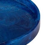 Close-up of the glossy marbled blue resin surface and raised edge of the round tray
