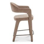Side profile highlighting stool’s curved backrest and metal footrest bars