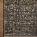 Close-up of the rug's fringed edge and detailed antique-inspired pattern on wooden floor