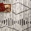 Close-up of rug with tray styling showing textured charcoal linear diamond pattern on dove background