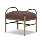 Three-quarter side view showing plush cushion and curved bronze arms meeting wooden legs