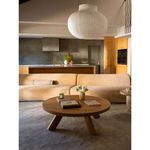 Side view of Naomi Concave Modular Sectional in a modern living room with wooden furniture and kitchen background