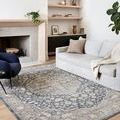 Teagan Denim / Mist Rug styled in a living room with gray sofa and modern navy chair on light wood floor