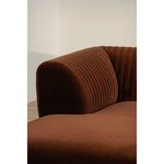 Close-up of left armrest showing rounded shape and detailed vertical tufting in brown velvet