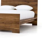Close-up of bed footboard showing dark oak grain and natural color variation