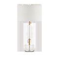 Deville Table Lamp centered on white background with clear optic crystal base, brass stem, and white drum shade