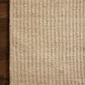 Corner detail focusing on whip-stitched edge and vertical stripe texture of Loloi Elma Natural Rug on wood floor