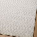 Close-up of rug surface and edge in natural light highlighting neutral colors and pattern