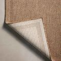 Corner of rug flipped to show its woven underside and sturdy edge stitching