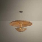 Draco Pendant illuminated in a neutral room with soft shadow on ceiling showcasing light filtering through wicker