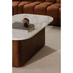 Dash coffee table styled with books and decorative sphere, positioned on off-white carpet