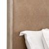 Close-up of side edge of Emmett Bed’s headboard showing tan upholstery and wood frame