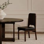 Kerr dining chair next to round wood table in styled dining room setting with decorative vase