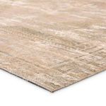 Close-up of rug corner showing texture and weave with muted tan and green distressed pattern