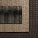 Three rugs layered to show color variations with brown rug at bottom, beige middle, and dark gray top