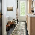 Runner length Humphrey Forest Multi Rug on black floor in a well-lit bathroom with natural wood cabinets