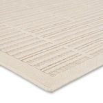Angled close-up showing stitched edge and textured borders in cream and beige linear design