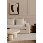 Voyager painting on wall above light-colored sofa and round coffee table in neutral-toned living room