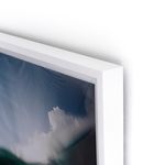 Close-up of the white frame corner edge with textured wall background and photograph detail