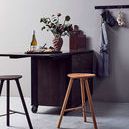Yami Brown bread board styled upright on kitchen counter next to stools and hanging gray apron