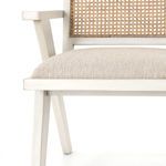 Close detail on cream oak frame edge and cushion seam at chair’s armrest junction