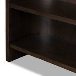Close-up of lower shelves and inner side panel with curved back of Lockhart Bookcase