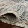 Rolled edge of ivory rug showing dense pile and polypropylene woven backing on hardwood