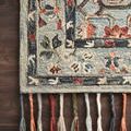 Detailed view of rug corner on dark wood floor with emphasis on soft wool pile and intricately looped floral patterns