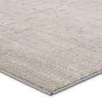 Close-up corner view showing the rug's low and high pile texture blending beige and gray tones