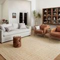 Polly Straw rug styled in a living room with neutral furniture and wood flooring