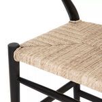 Close-up of woven seat corner secured by wrapped weave around black teak frame