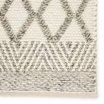 Close-up of detailed edge with varied knitting styles and gray diamond motifs