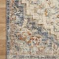 Close detail of rug corner showing beige fringe and intricate faded pattern on wood floor