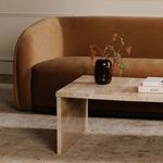 Rosa coffee table styled in living room with brown velvet sofa, books, and decorative vase on top