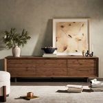 Media console in room with modern decor and plush chair partially visible