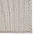 Close-up of rug edge with braided border detailing in light gray