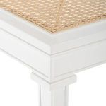 Close-up of cane seat panel framed by white lacquered wood with subtle molding detail