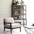 Curio cabinet displayed with brown leather armchairs and beige cowhide rug underneath