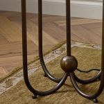 Detailed view of lamp base with bronze spherical center and power cord on decorative rug