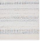 Close-up of a rug corner highlighting repeating tribal patterns and tightly woven border details