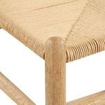 Macro shot of woven seat fibers tightly wrapped around oak stool frame corner