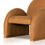 Angled close-up displaying thick cushioned seat and vertical seams along leather armrest